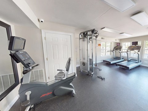 A gym with treadmills, elliptical machines, and other exercise equipment.