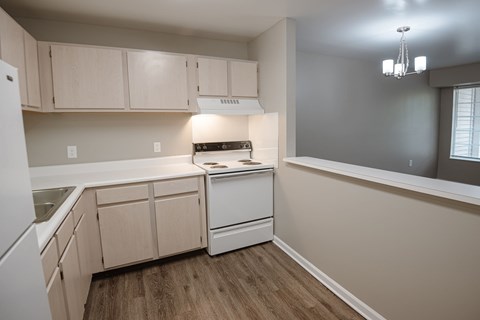 A kitchen with a white dishwasher and white cabinets.