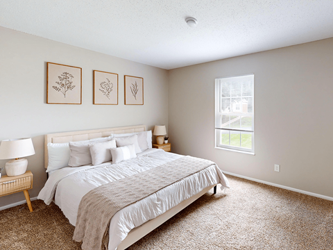 A bedroom with a large bed and a window.
