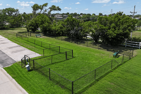 A black fence encloses a green lawn.