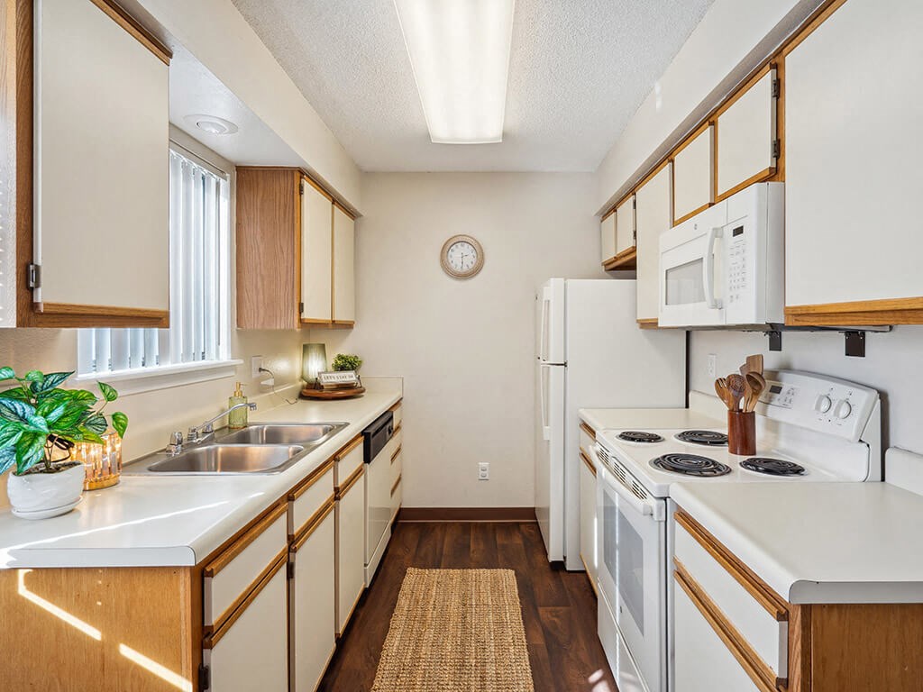 a kitchen with white appliances and wooden cabinets