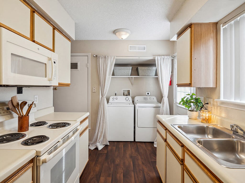apartment kitchen with a stove, microwave, and a sink