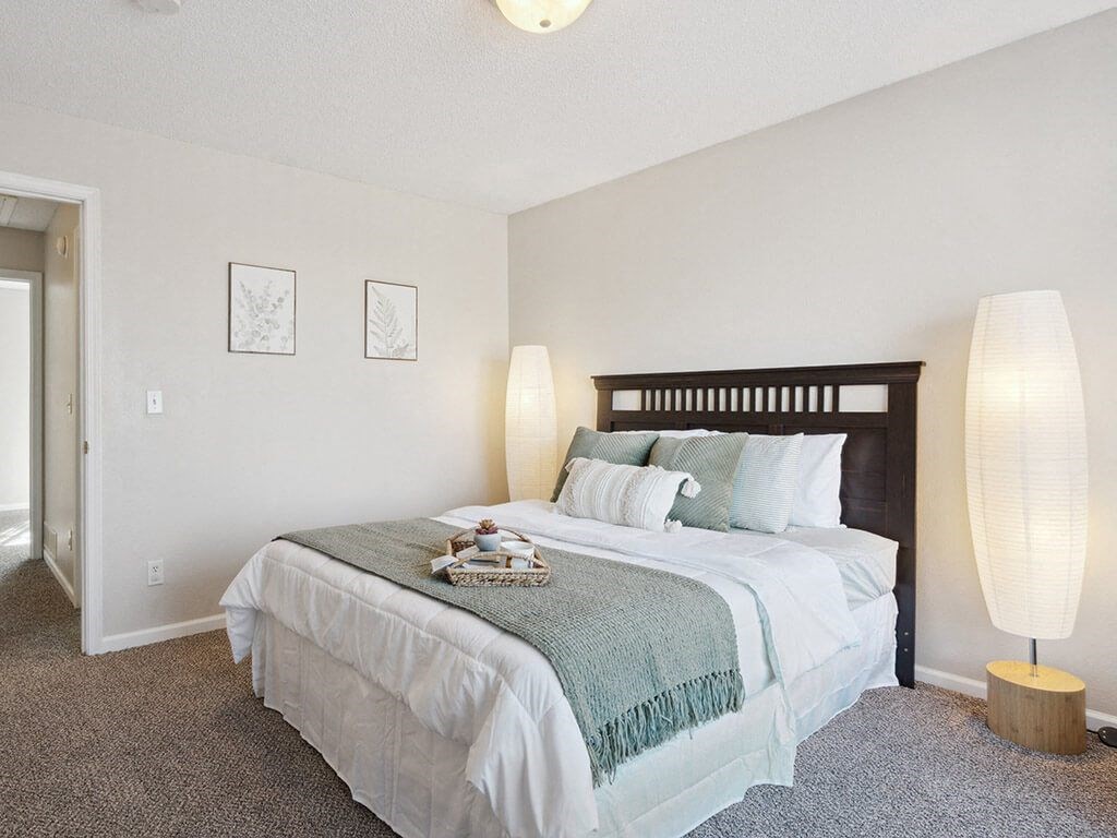 townhome bedroom with a bed and two lamps