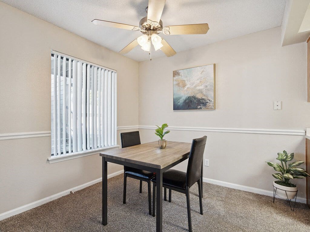 apartment dining room with a table and a ceiling fan