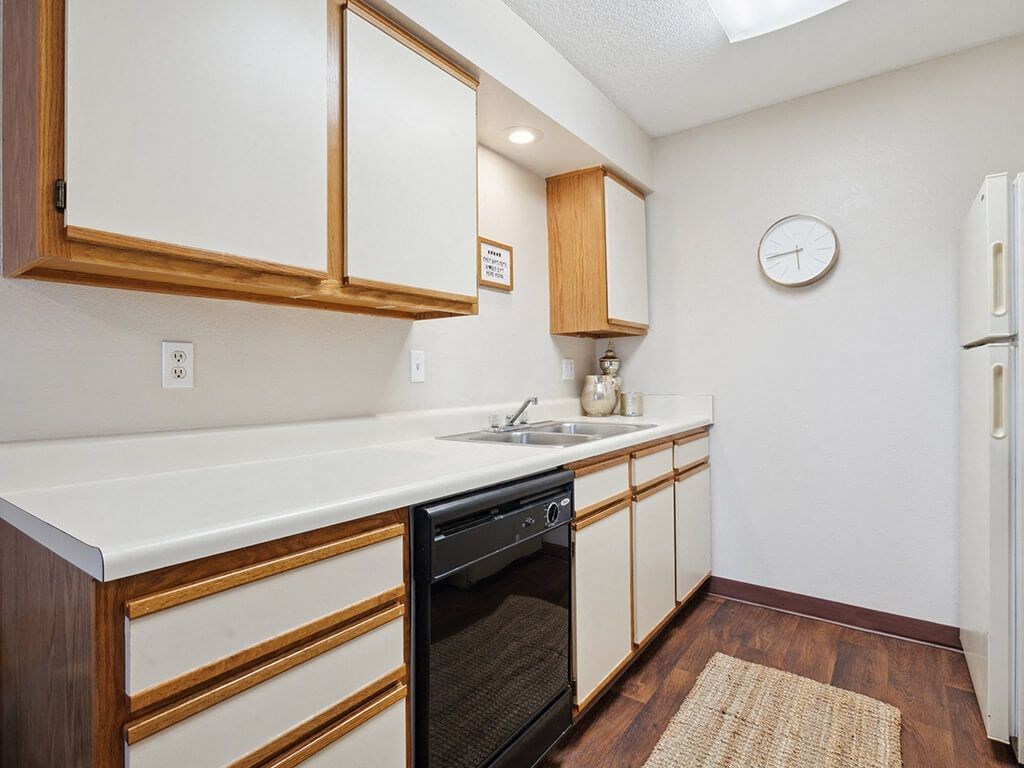 a kitchen with white cabinets and a black dishwasher