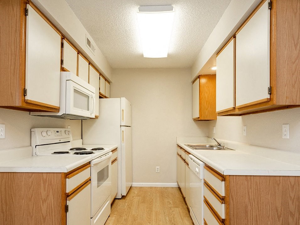 a kitchen with white appliances and wooden cabinets