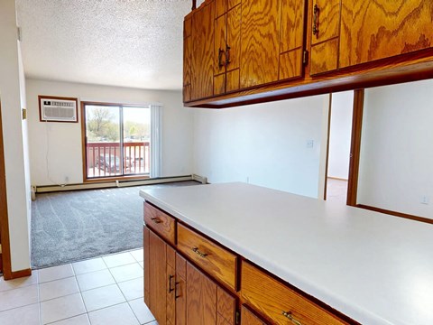 A kitchen with wooden cabinets and a white counter top.