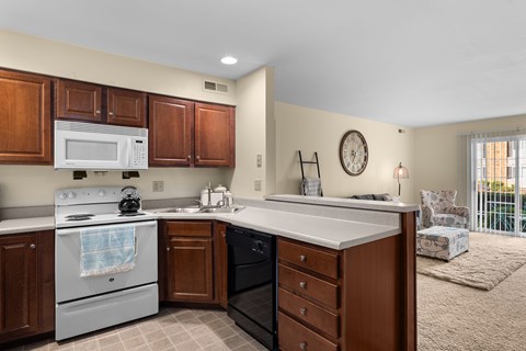A kitchen with a white stove top oven and a white microwave above it.