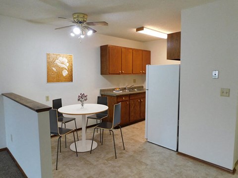a kitchen with a dining table and a refrigerator