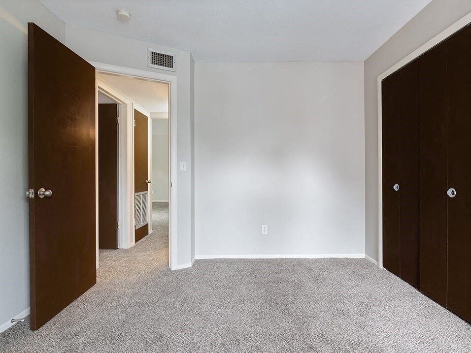 a bedroom with a closet and a door to a hallway
