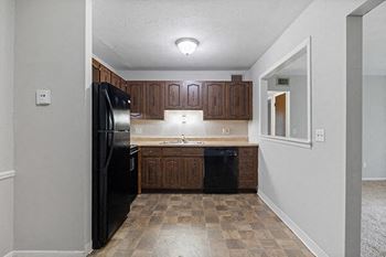 a kitchen with a black refrigerator and a sink