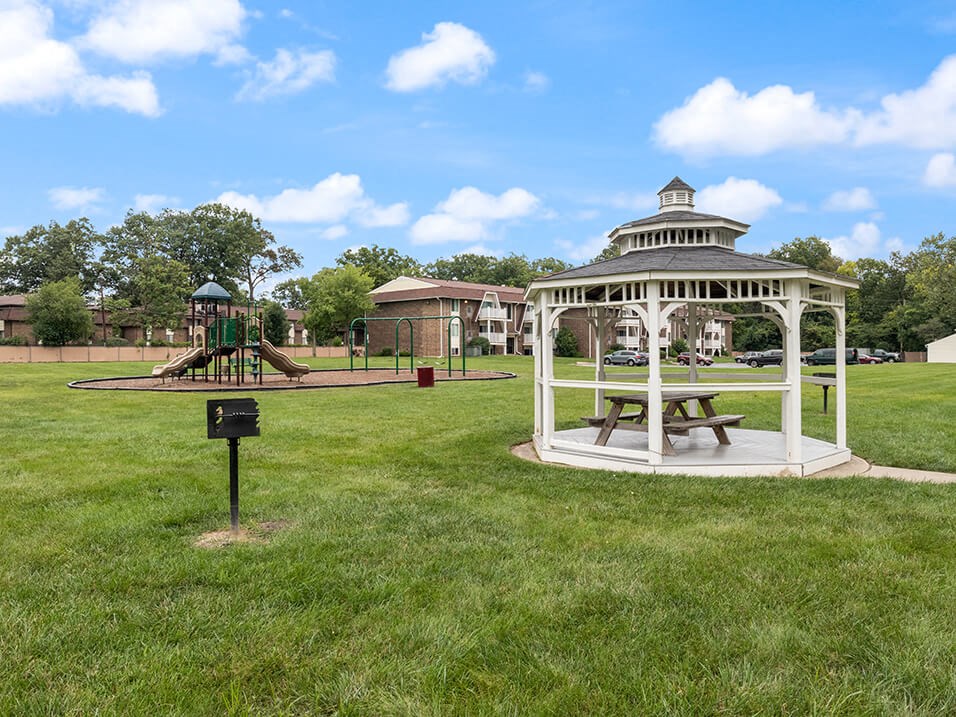 a gazebo with a playground in a park