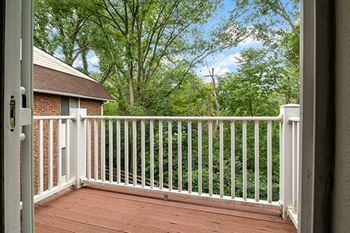 a balcony with a view of a yard and trees