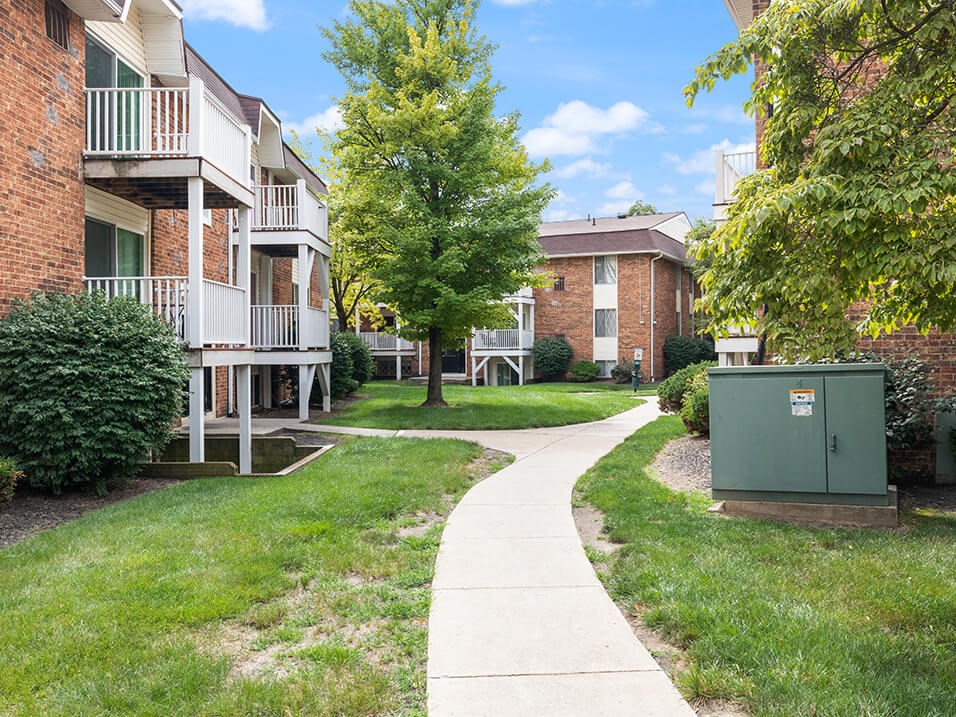 our apartments have a walkway with grass and trees