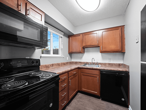 a kitchen with black appliances and a granite counter top
