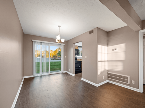 an empty living room with a sliding glass door to a yard