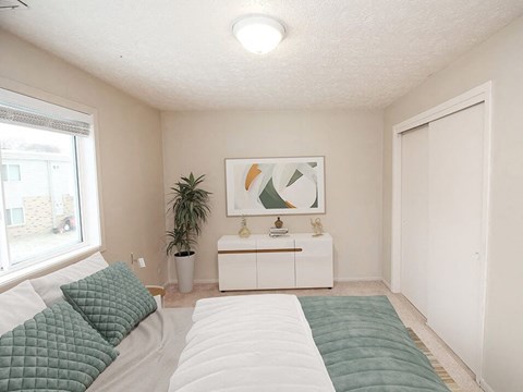 a bedroom with a large bed next to a window