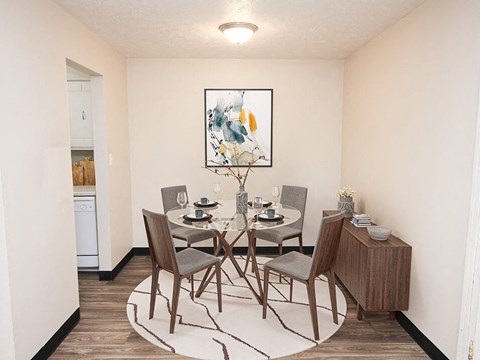 a dining room with a table and chairs and a painting on the wall