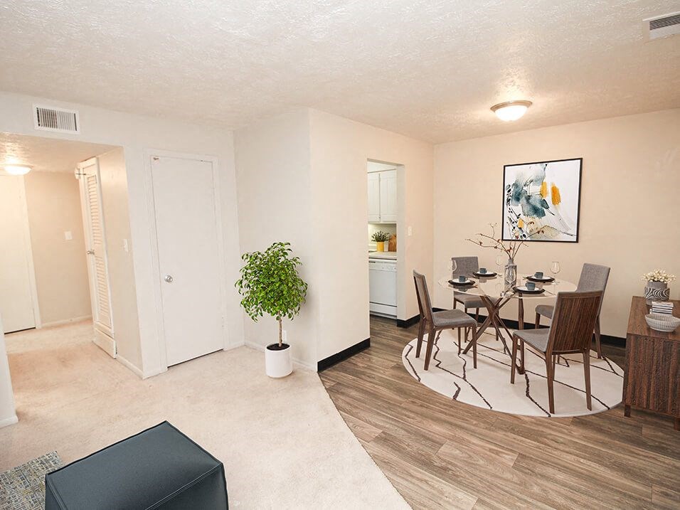 a living room and dining room with a table and chairs