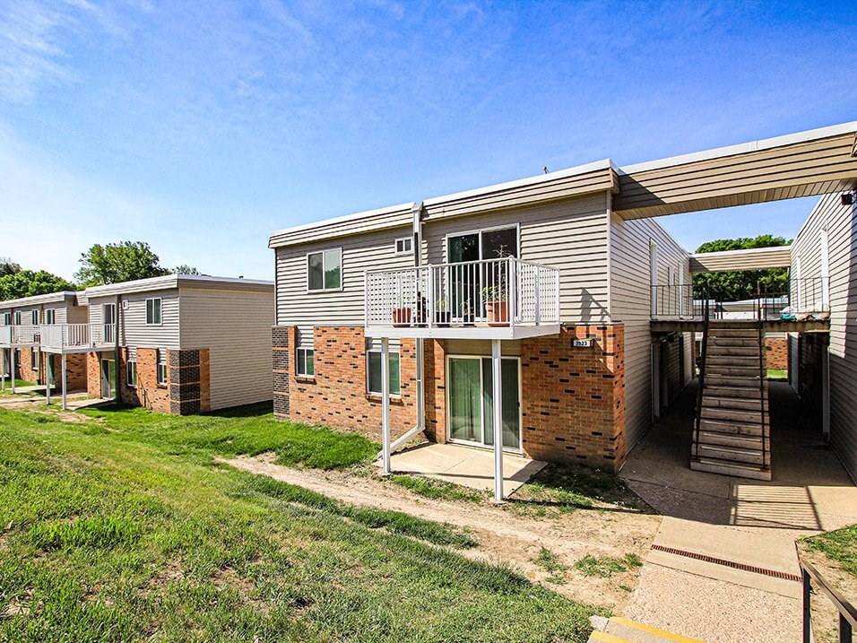 a row of houses with a stairway leading up to a balcony