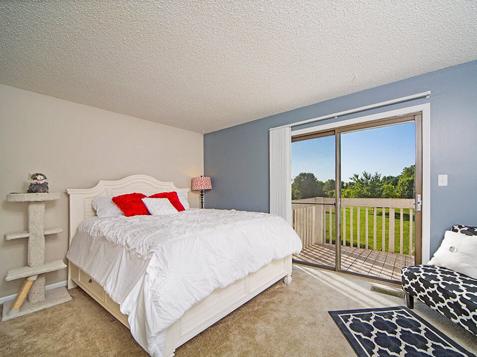 Primary bedroom with Attached Balcony at Indian Woods Apartments in Evansville