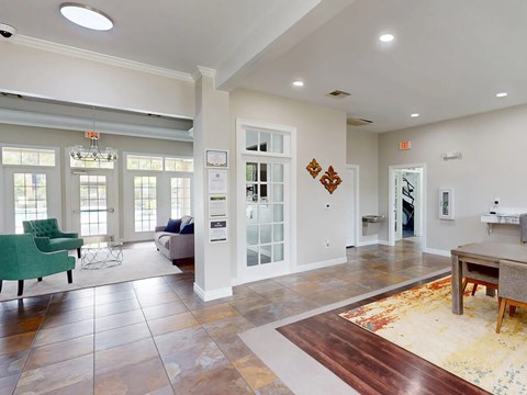 A living room with a green chair and a brown rug.