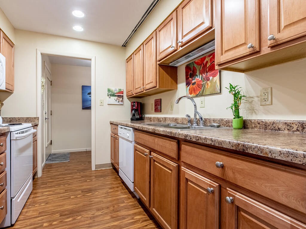 A kitchen with wooden cabinets and a granite countertop.