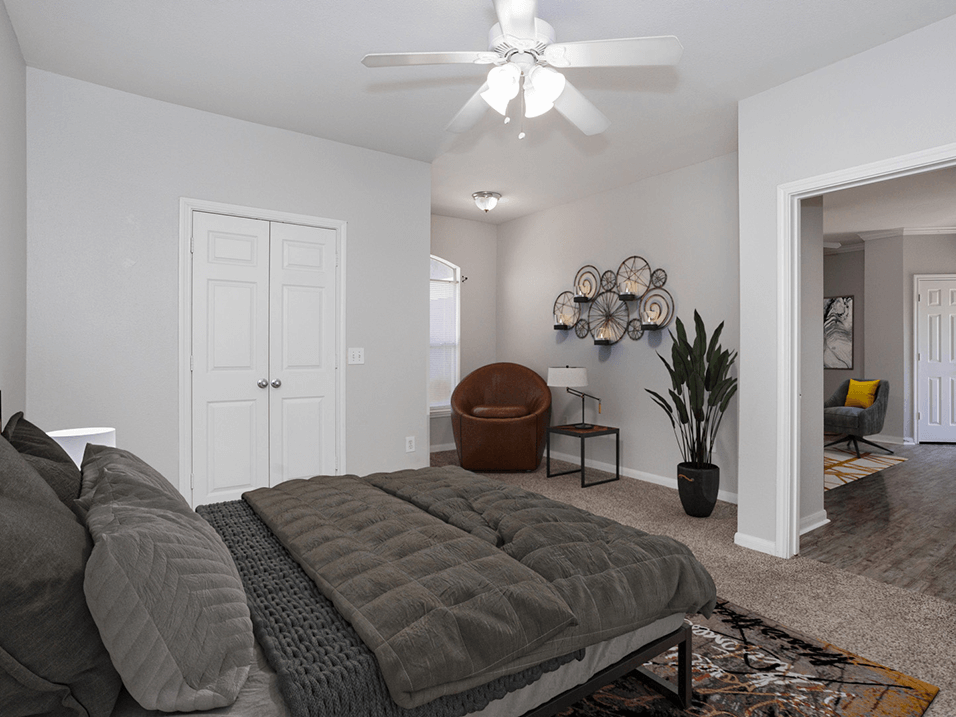 a bedroom with a bed and a ceiling fan