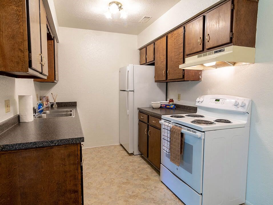 a kitchen with a stove refrigerator and sink