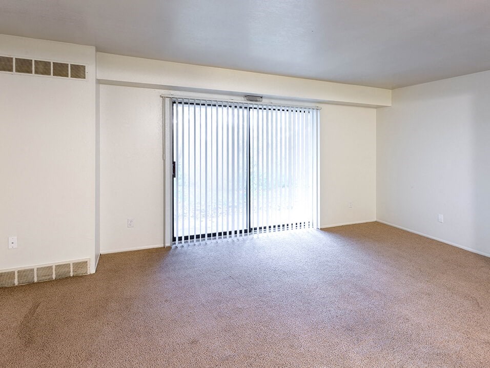 an empty living room with a sliding glass door