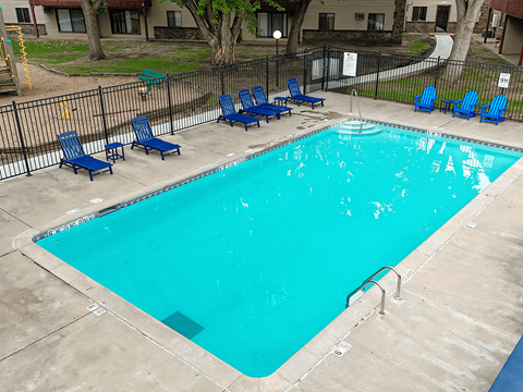 A small pool with blue chairs around it.