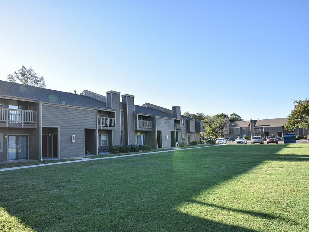 Apartment complex with a green lawn in front.