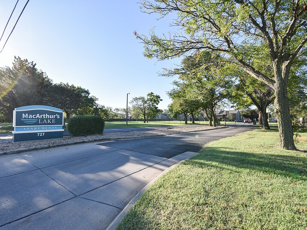 A sign for MacArthur's Lake is visible on the side of a road.