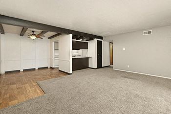 an empty living room with a ceiling fan