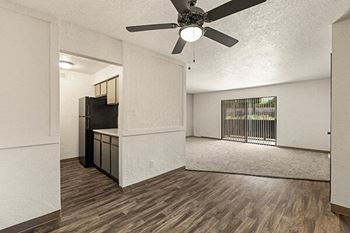 an empty living room with a ceiling fan