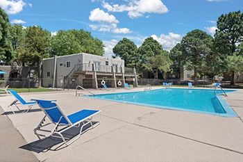 a swimming pool with two lounge chairs next to it
