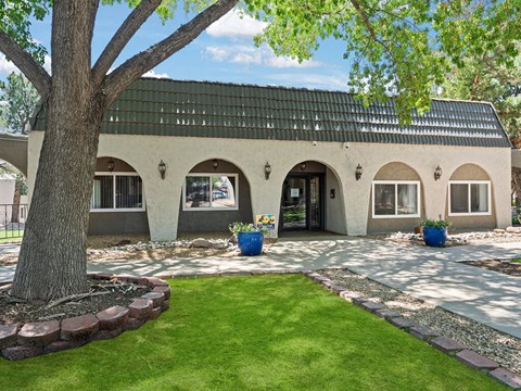the front of a house with a yard and a tree
