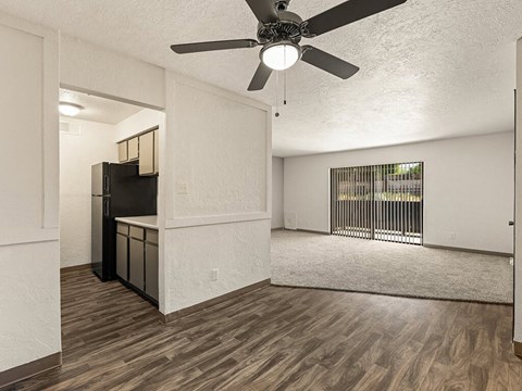an empty living room with a ceiling fan