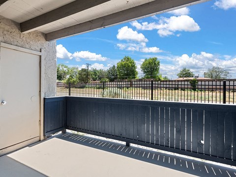 a view of a balcony with a blue sky and some clouds