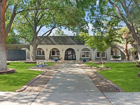 a building with arches and a field of grass