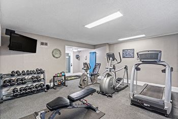 a gym with exercise equipment and a tv