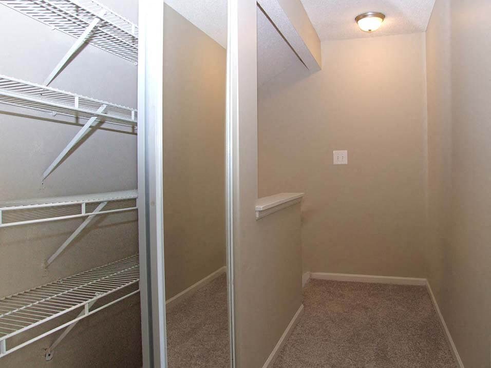 a walk in closet in a home with a mirrored door