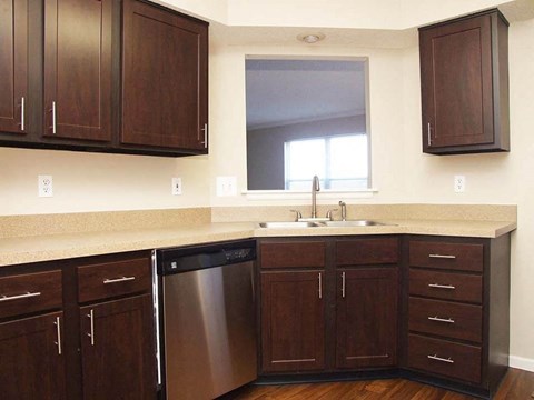 a kitchen with wooden cabinets and a sink and a window