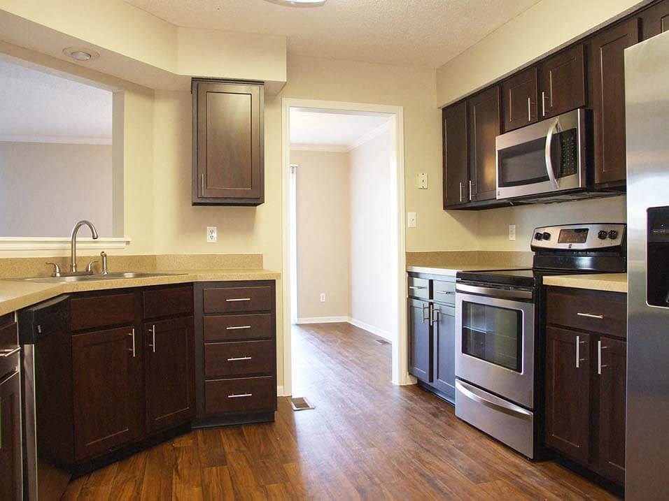 a kitchen with wooden floors and stainless steel appliances