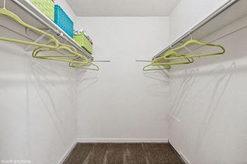 a white closet with yellow cords hanging on the wall