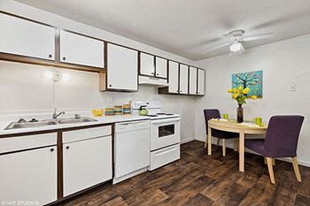 a kitchen with white cabinets and a dining table