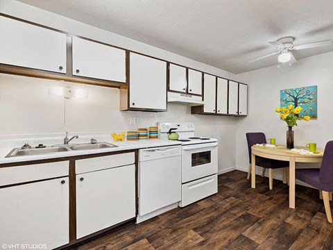 a kitchen with white cabinets and a dining room table