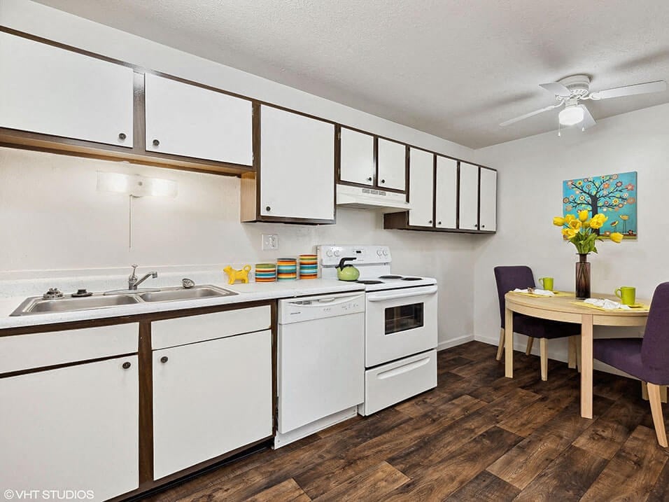 a kitchen with white cabinets and a dining room table