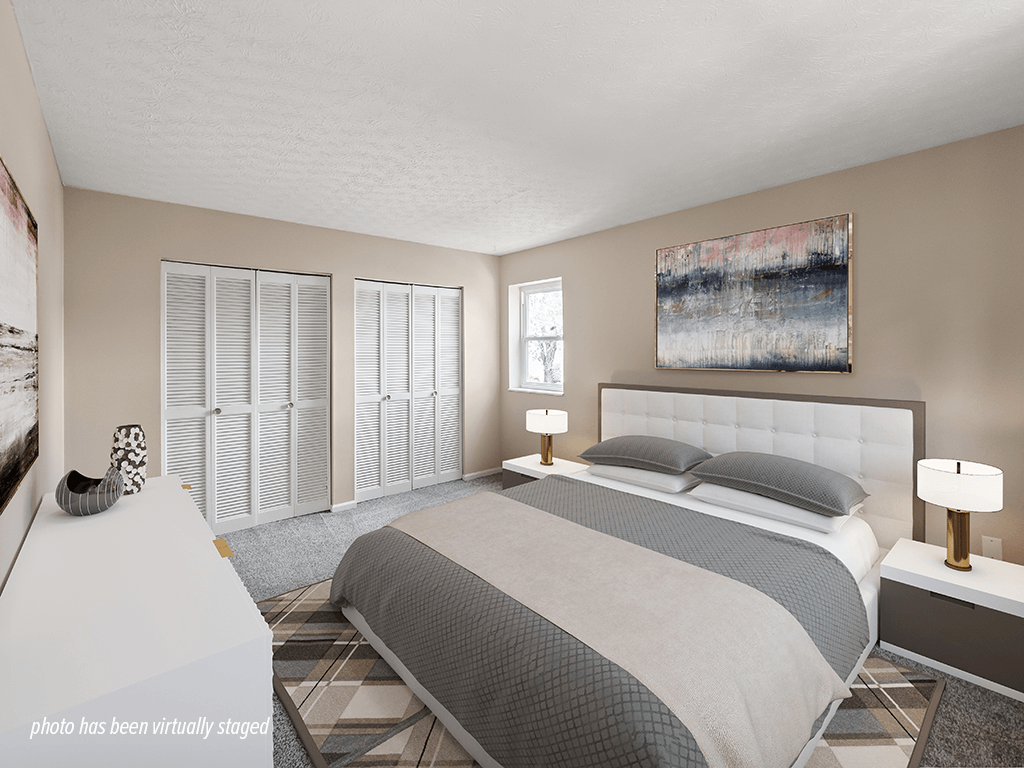 A bedroom with a large bed and a painting on the wall.