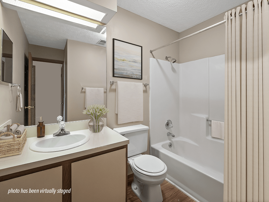 A bathroom with a white toilet, sink, and bathtub.